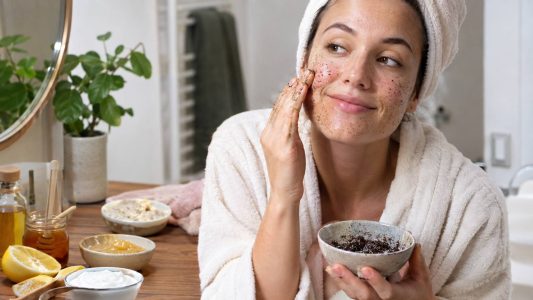 Une femme qui s'applique un gommage sur le visage